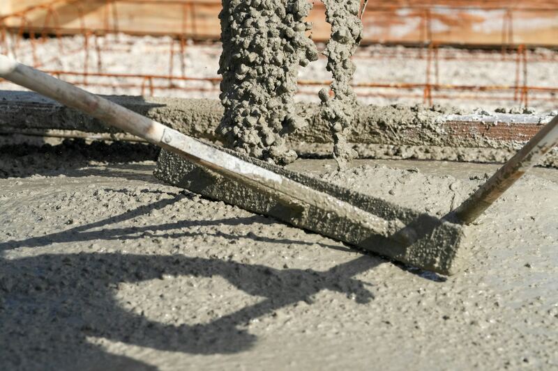 Béton frais tiré à la règle sur une dalle.